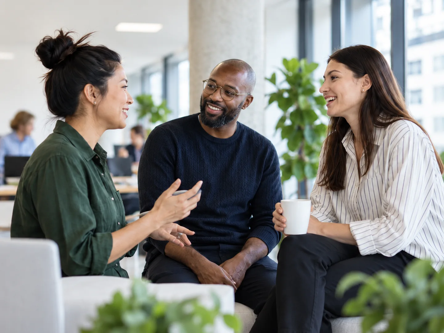 Three colleagues sharing ideas in a bright office. Illustrative scene.